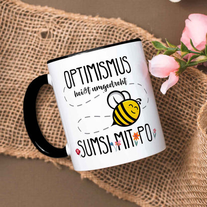 Bedruckte Tasse mit Spruch - Optimismus heißt umgedreht Sumsi mit Po