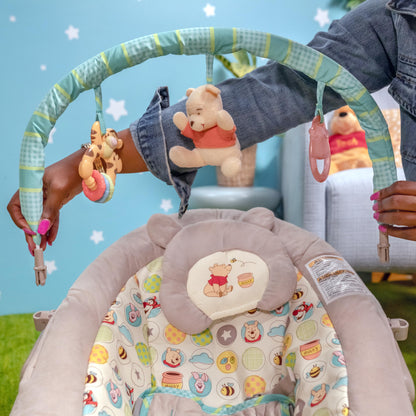 Bright Starts, Disney Baby, Winnie the Pooh Babywippe Babyschaukel mit Vibrationen, Automatischer Ausschaltfunktion, Melodien, Lautstärkeregler, Abnehmbarer Kopfstütze und Spielbogen