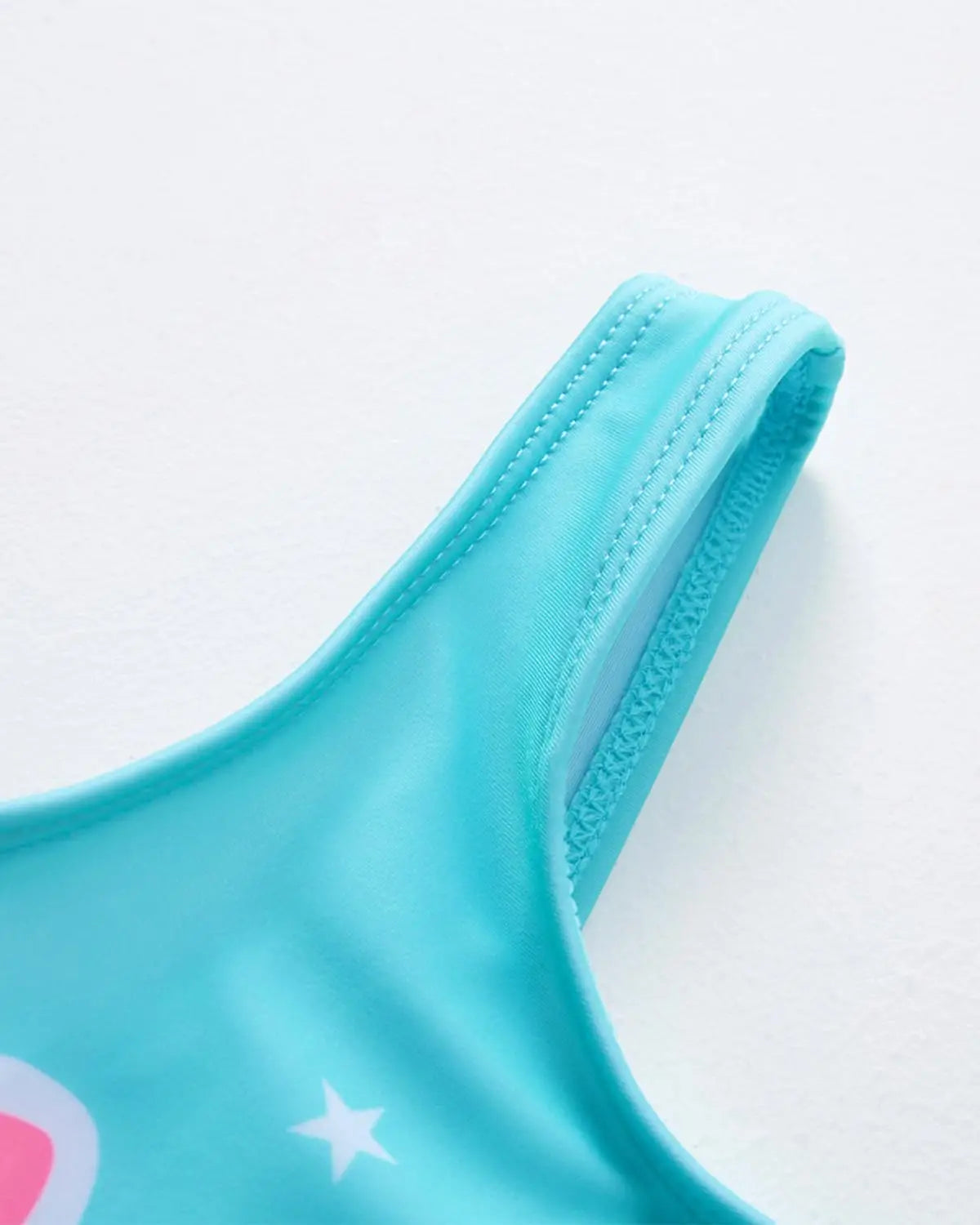 Turquoise einteiler schwimmanzug mit weißem stern und pinkem rundem detail auf dem schulterriemen für mädchen von 2 bis 9 jahren